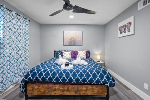 a bedroom with a blue bed with a ceiling fan at Houston Heights 2BR Getaway with Pool & Free Park in Houston