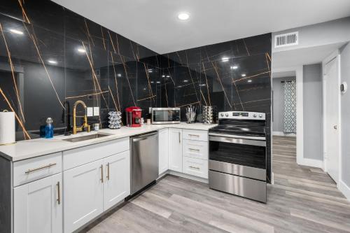 a kitchen with white cabinets and stainless steel appliances at Houston Heights 2BR Getaway with Pool & Free Park in Houston