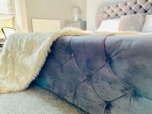 a large bed with a furry blanket on it at Fulwood guest house in Preston
