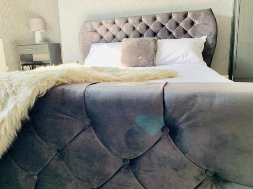 a bedroom with a large bed with a gray headboard at Fulwood guest house in Preston