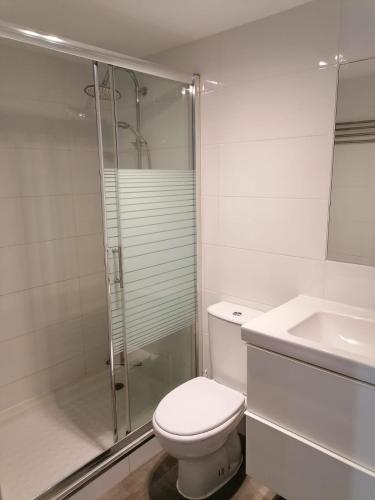 a bathroom with a toilet and a shower and a sink at Appartamento Puerta del Sol in Caleta De Fuste