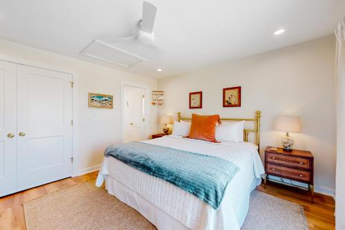 a white bedroom with a bed and a night stand at Kermit's Place in Fort Morgan