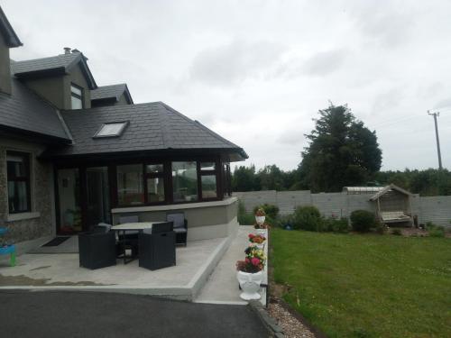 a house with a porch with a table and chairs at Blackbrink cottage in Roscommon