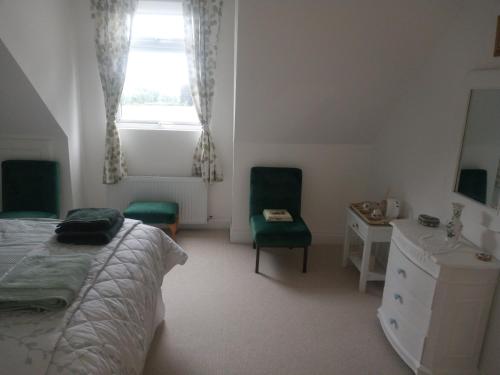 a bedroom with a bed and a desk and a window at Blackbrink cottage in Roscommon