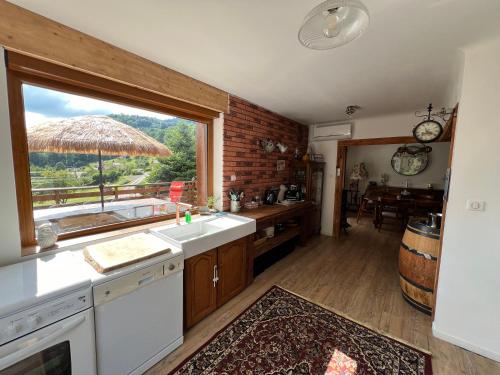 une cuisine avec un évier et une grande fenêtre dans l'établissement Chalet individuel - Panoramique montagnes & Proche LAC, à La Bresse