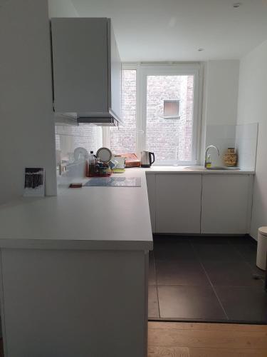 une cuisine avec un comptoir blanc et une fenêtre dans l'établissement Flat Sainte Anne Lille, à Lille