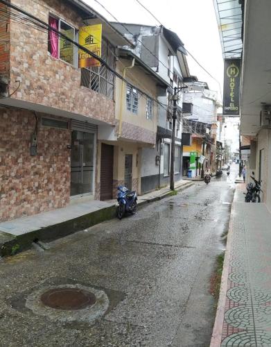an empty street with a motorcycle parked on the side of a building at Hotel federal in Quibdó
