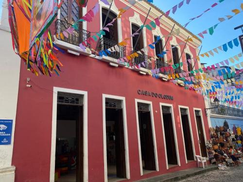 a red building with flags and kites hanging from it at A Casa dos Mestres in Salvador
