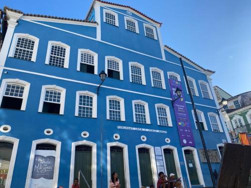a blue building with people standing in front of it at A Casa dos Mestres in Salvador