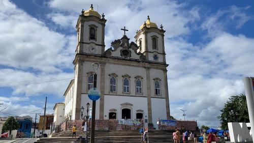 a large white church with a clock tower at A Casa dos Mestres in Salvador