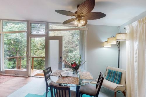 a dining room with a table and a ceiling fan at Tranquil Island Escape in Kehena