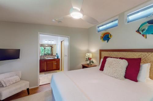 a bedroom with a white bed and a chair at Tranquil Island Escape in Kehena