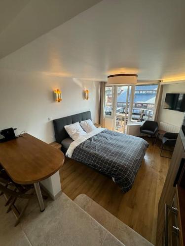 une chambre avec un lit et une table dedans dans l'établissement Beau studio neuf, vue Marina, à Deauville
