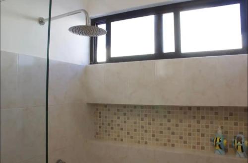 a bathroom with a shower with a glass door at Casa Mar in Chelem