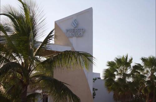 a sign on the side of a building with palm trees at Casa Mar in Chelem