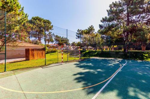 a tennis court with a net on top of it at Private Lake Condo Apartment - Tróia in Troia