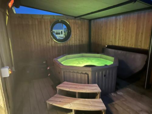 a sauna with a tub and two benches in it at Humberston Boathouse Lodge & Hot Tub - Cleethorpes Beach Cabin Chalet in Humberston