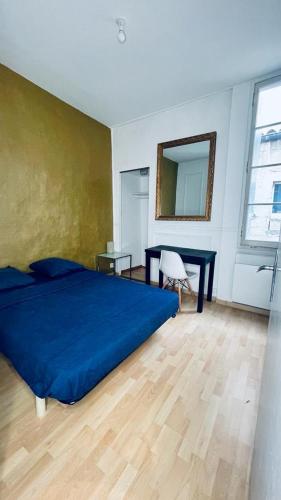 une chambre avec un lit bleu et un miroir dans l'établissement Appartement hausmanien centre Montpellier, à Montpellier