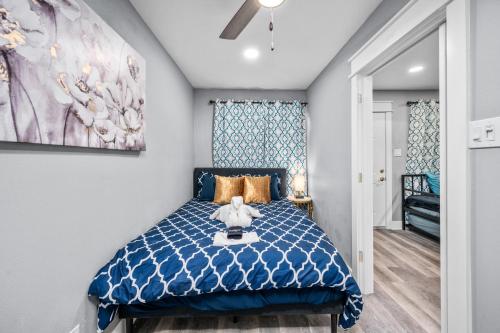 a bedroom with a blue bed and a painting on the wall at Central Heights 2BR Oasis with Pool & Free Park in Houston