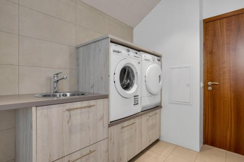 a kitchen with a washing machine and a sink at Thorsplan Luxury Apartment in Hafnarfjördur