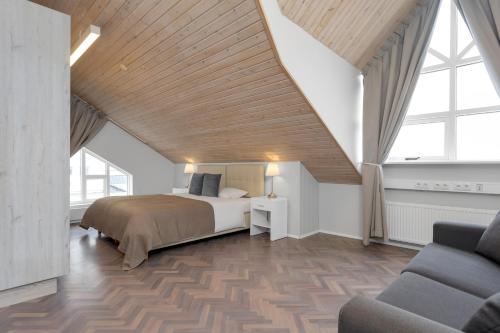 a bedroom with a bed with a wooden ceiling at Thorsplan Luxury Apartment in Hafnarfjördur