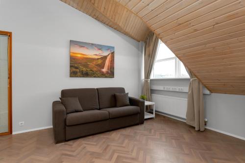 a living room with a couch and a painting on the wall at Thorsplan Luxury Apartment in Hafnarfjördur