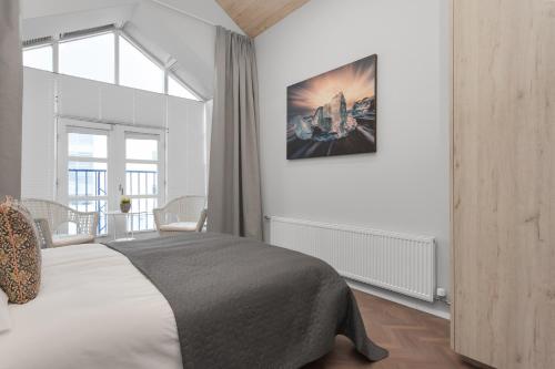 a bedroom with a large bed and a large window at Thorsplan Luxury Apartment in Hafnarfjördur