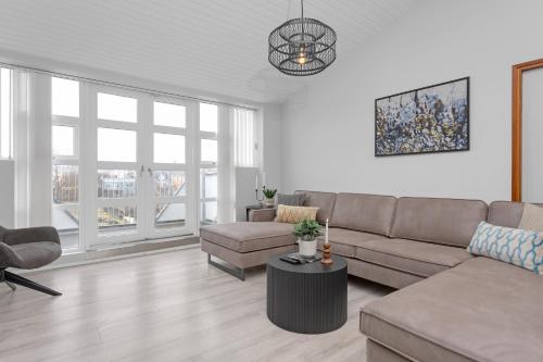 a living room with a couch and a table at Thorsplan Luxury Apartment in Hafnarfjördur