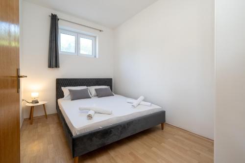 a bedroom with a bed with white sheets and a window at Apartment Povljana 224d in Povljana