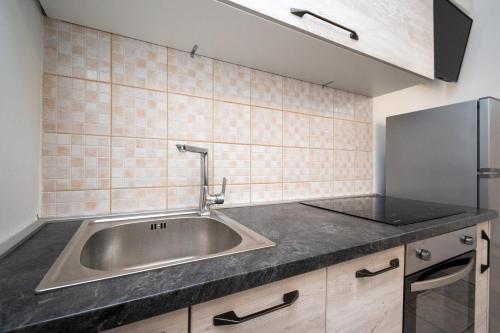 a stainless steel sink in a kitchen with tiles at Apartment Povljana 224d in Povljana