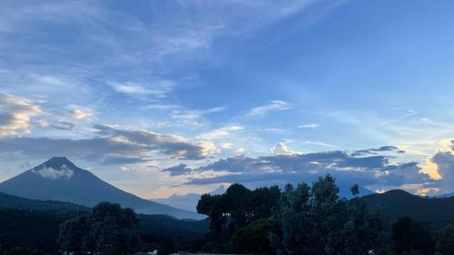 a mountain in the distance with a cloudy sky at Espacio Milpas Altas in Santa Lucía Milpas Altas