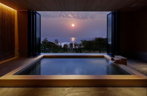 una piscina en una casa con una gran ventana en 間人温泉 炭平, en Kyotango