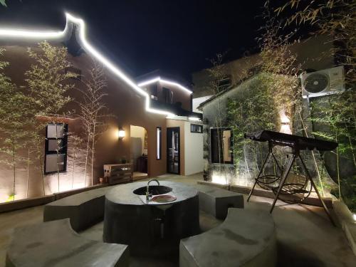 a patio at night with a table and a tripod at Waiting for the Blossoms B&B Tea House in Shantou
