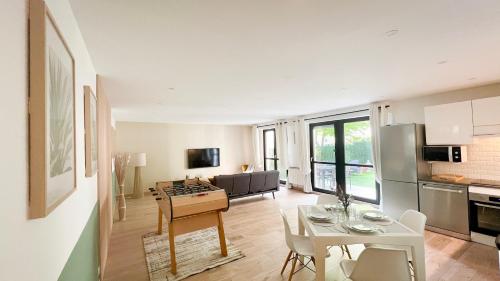 une cuisine et un salon avec une table et des chaises dans l'établissement PALM SERENITY avec jardin - Paris - Disneyland, à Champs-sur-Marne
