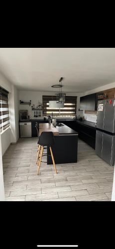 une cuisine avec une table et un réfrigérateur dans l'établissement Loft spacieux et agréable près des châteaux, à Menars