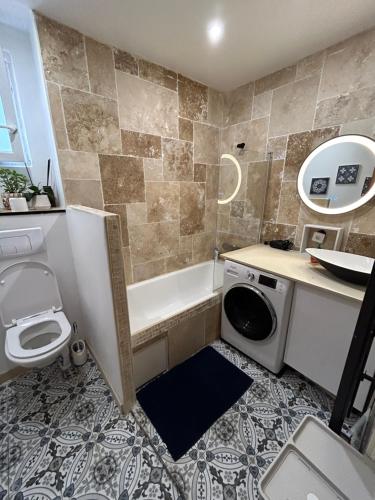 une salle de bain avec baignoire et machine à laver dans l'établissement Grand duplex, à Nice