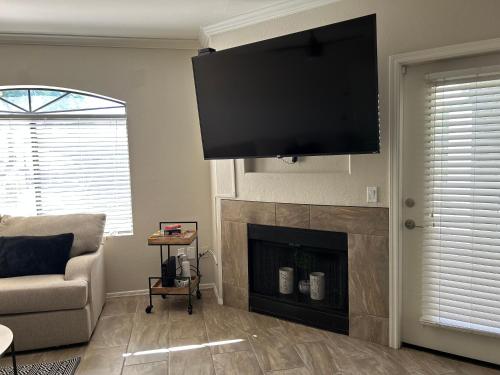 a living room with a flat screen tv above a fireplace at Stay in Style Scottsdale 1st Floor Condo in Scottsdale