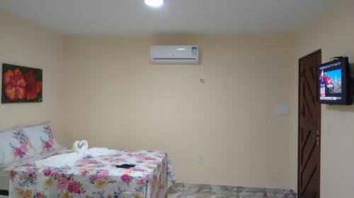 a bedroom with a bed and a tv in it at Chalé Alto Mar Flats in São Miguel do Gostoso