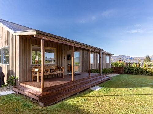 a house with a deck with a picnic table on it at Hepburn Haven Retreat in Hanmer Springs