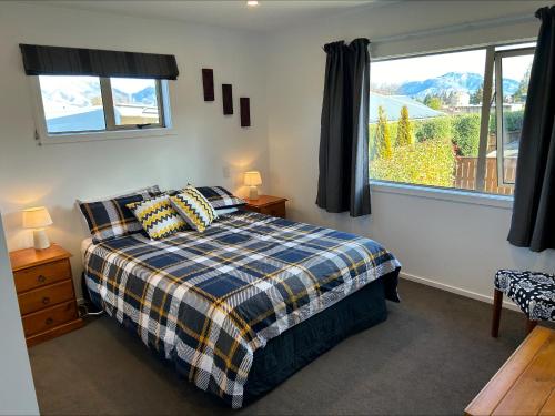 a bedroom with a bed and a large window at Hepburn Haven Retreat in Hanmer Springs