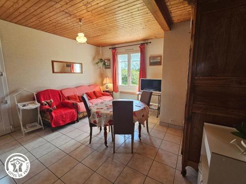 un salon avec une table et un canapé rouge dans l'établissement Gîte familial avec jardin privé et barbecue près de La Barre-de-Monts - FR-1-426-104, à La Barre-de-Monts