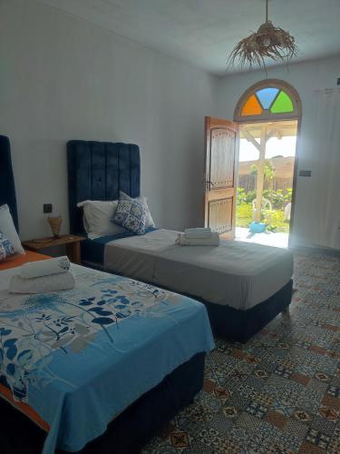 a room with two beds and a window with a window at Darna 4 in Demina