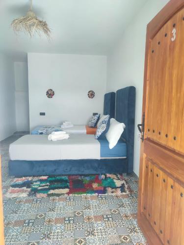 a bedroom with a bed and a wooden door at Darna 4 in Demina