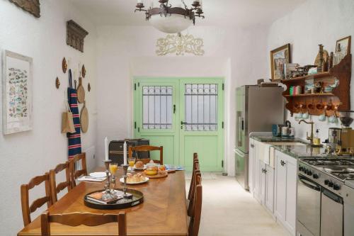 a kitchen with a wooden table and a green door at Seaside holiday house Zaton, Krka - 23406 in Zaton