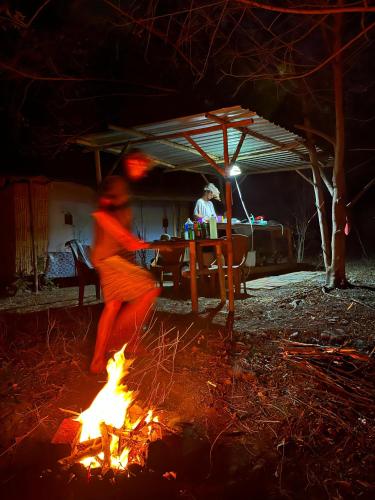 a person dancing around a fire at night at Jungle Glamping Tent Two in Maluk