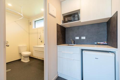 a small bathroom with a sink and a toilet at Te Anau Top 10 Holiday Park and Motels in Te Anau