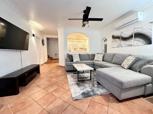 a living room with a couch and a flat screen tv at Villa 122 Sugar Hill Estate, pools, tennis, gym, 5 mins to beach in Saint James