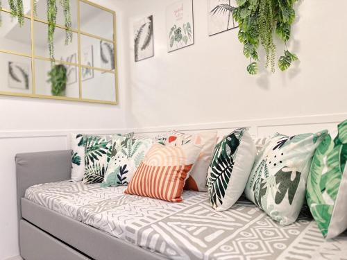 a couch with pillows on it in a room at Apaisante Tropical Lodge in Tagaytay