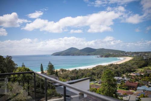 a view of a beach from a balcony at Dreamtime Beach Retreat - 4 Bedroom with Ocean View in Forster