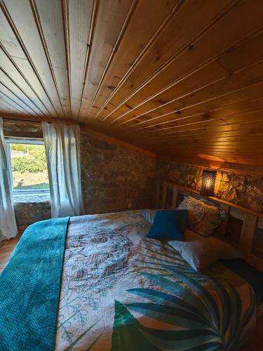 a bed in a room with a wooden ceiling at Angel's House in Alcobaça